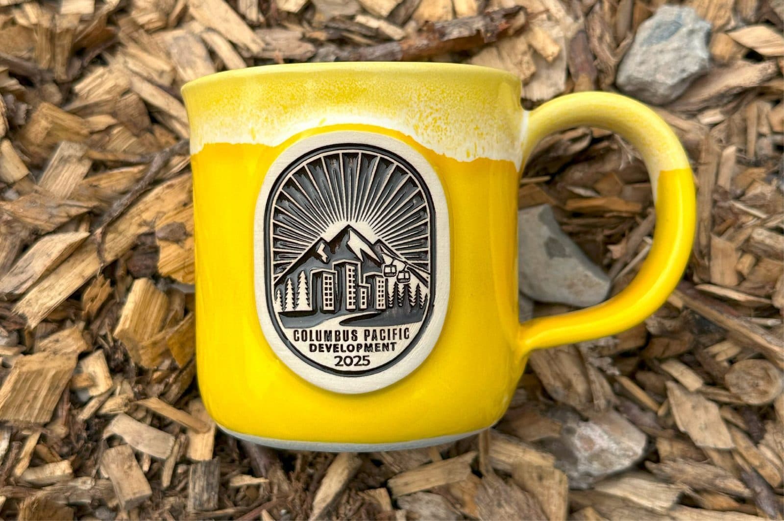 Yellow Columbus Pacific Development custom mug on woodchips