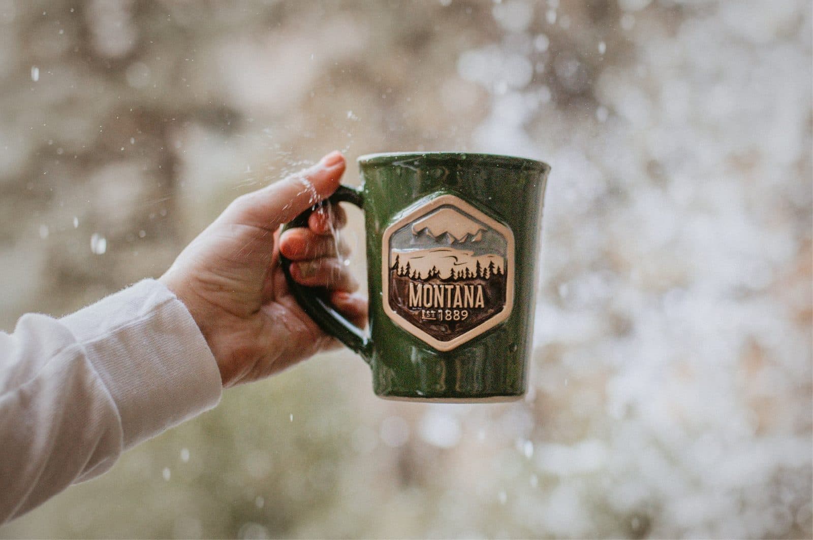 Montana 1889 custom mug held in fresh snow